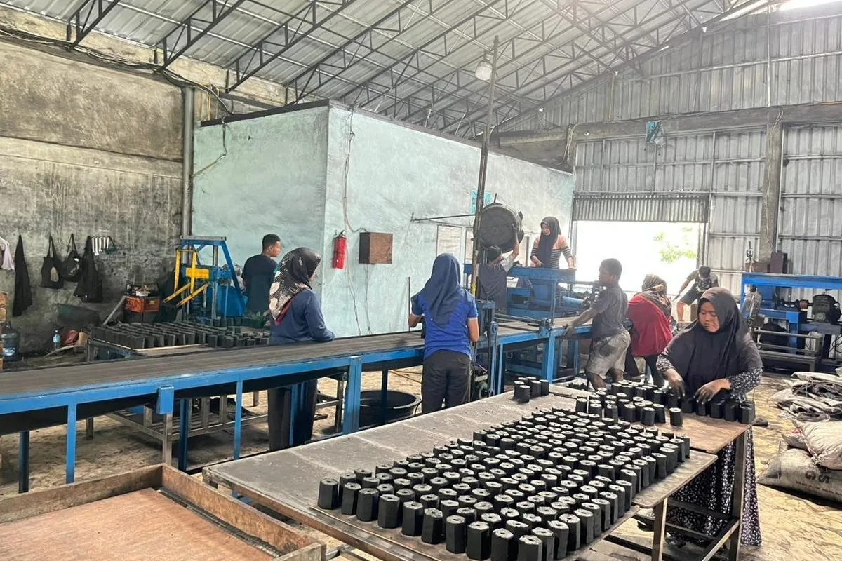 The FAMALA production floor in North Sumatra: extrusion line, cutting tables and freshly pressed briquettes laid out to dry