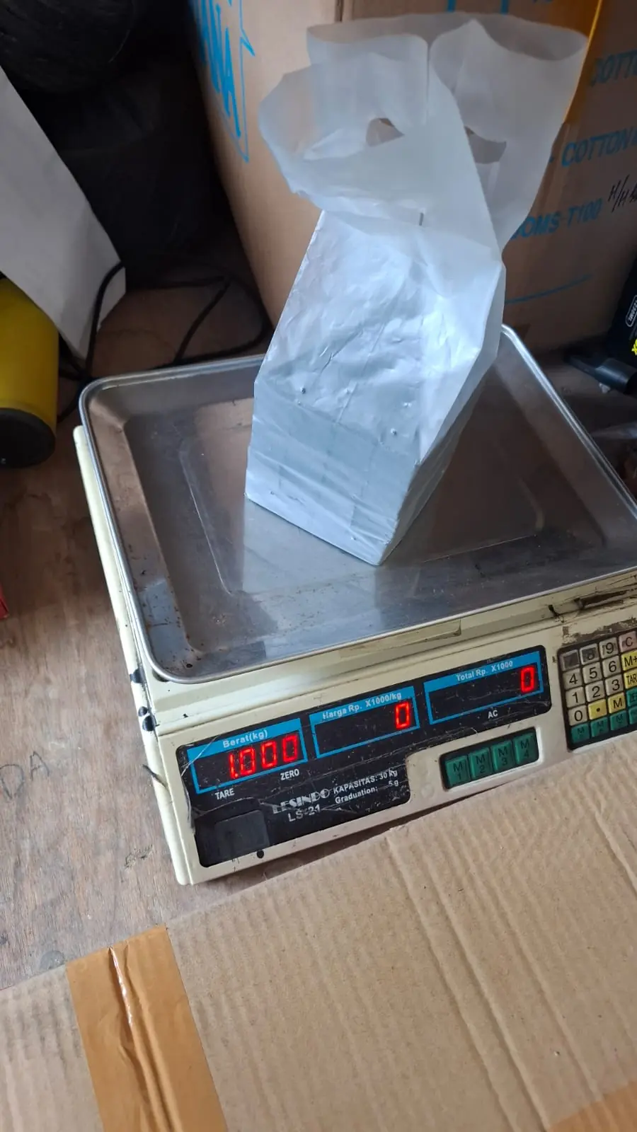 Digital scale showing 1.000 kg for a sealed inner bag of charcoal cubes